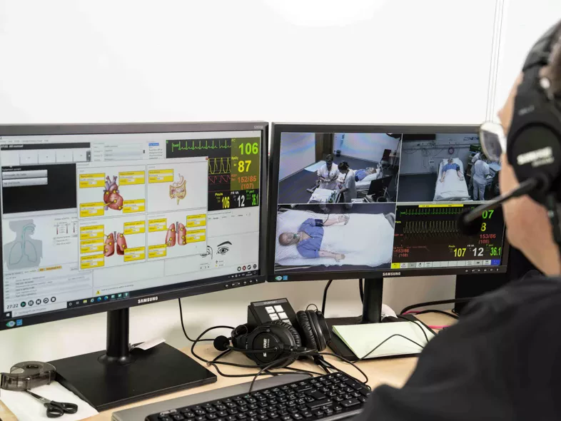 un technicien en simulation devant ses écrans en régie
