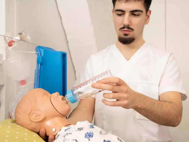 Etudiant infirmier avec mannequin de bébé